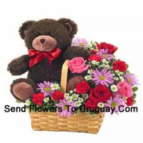 Um belo cesto feito de rosas vermelhas e rosas cor-de-rosa, cravos vermelhos e outras flores roxas variadas, juntamente com um fofo urso de pelúcia de 14 polegadas de altura