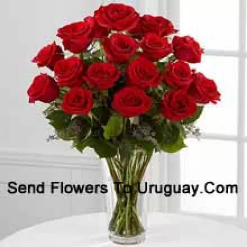 18 Rosas rojas con algunos helechos en un jarrón