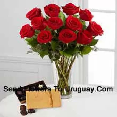 12 Rosas Rojas con algunos helechos en un jarrón y una caja de chocolates Godiva (Nos reservamos el derecho de sustituir los chocolates Godiva por chocolates de igual valor en caso de no disponibilidad de los mismos. Stock limitado)